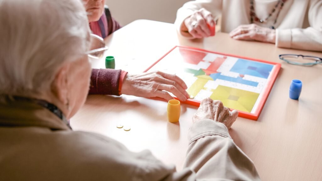 Senioren spielen bei der Demenzbetreuung in Herne gemeinsam ein Brettspiel am Tisch